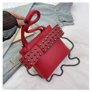Macro detail of red lychee leather phone bag with grey studs and silver chain strap