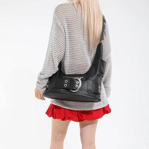 Chic black motorcycle shoulder bag with silver eyelets and a large metal ring buckle