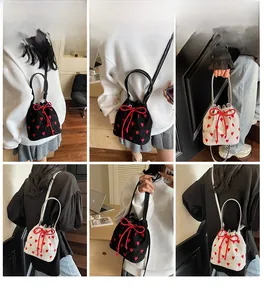 Detail of mini bucket bag with red heart embroidery and drawstring bow closure