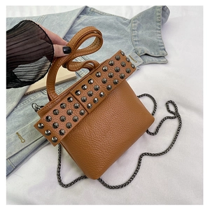 Close-up of brown litchi pattern leather bag with vintage silver rivet studs and chain strap
