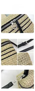 Gros plan du sac en paille beige avec rayures noires et détails de fermeture éclair