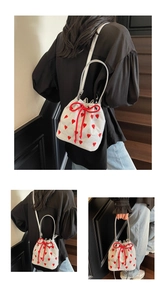 Detail of glitter silver bucket bag with red heart embroidery and drawstring bow