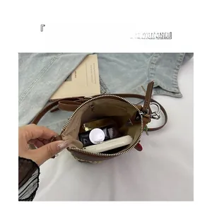 Detail showing inner storage of rainbow straw woven bag with cosmetics and zipper closure