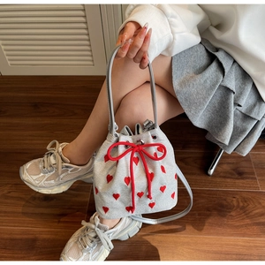 Detail of silver bucket bag with red heart embroidery and drawstring closure