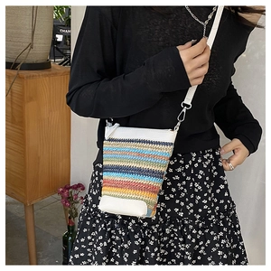 Gros plan du petit sac bandoulière tissé arc-en-ciel avec finitions en cuir blanc
