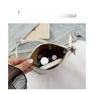 Detail of white leather crossbody bag interior showing spacious compartments and zip pocket