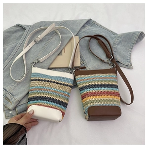 Détail du mini sac seau tissé coloré avec finitions en cuir et longue bandoulière