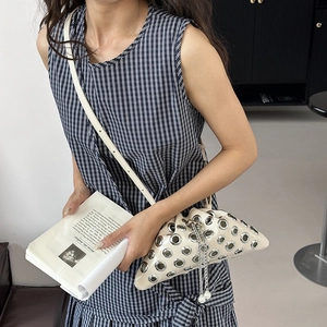 Chic punk style cream bucket bag with silver eyelets and pearl chain on a female model