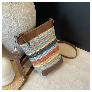 Vue de dessus montrant le tissage rayé coloré et les détails du zip de ce sac en paille
