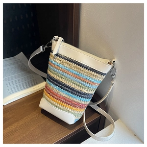 Détail du sac en paille tissée à rayures avec bordure en cuir blanc et fermeture éclair