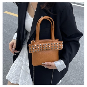 Close-up of brown pebbled leather mini bag featuring silver rivets and a large bow design