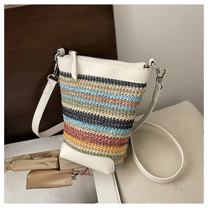 Détail du sac seau en paille à rayures colorées avec garniture en cuir blanc et zip