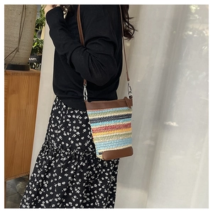 Détail du sac bandoulière tissé à rayures multicolores avec bandoulière en cuir brun