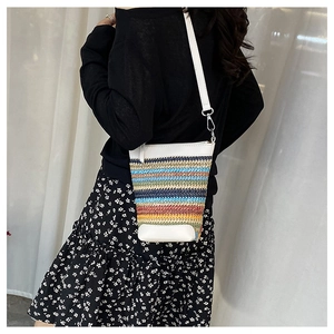 Détails de la texture du sac bandoulière en paille tissée multicolore et finitions cuir