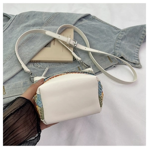 Détail du petit sac tissé coloré avec base en cuir blanc et fermoir en métal argenté