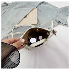 Vue intérieure du sac blanc montrant la doublure brune, la poche zippée et l'espace de rangement