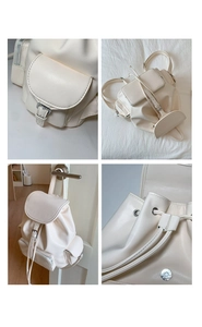 Detail view of cream white leather backpack with drawstring closure and silver buckles