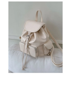 Detailed close-up of cream soft leather backpack with drawstring closure and side pockets