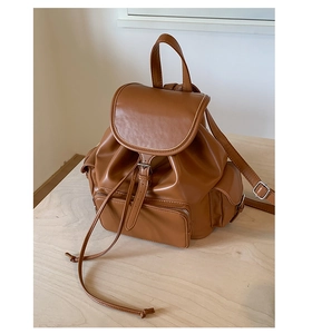 Close-up of vintage brown PU leather backpack texture with drawstring and front zipper pocket