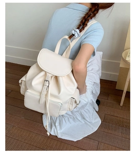 Detail of cream soft leather backpack with drawstring closure and front zip pocket