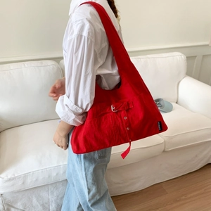 Grand sac cabas minimaliste en toile rouge porté à l'épaule pour femme