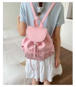 Pink PU leather backpack with drawstring closure and buckle flap shown on model