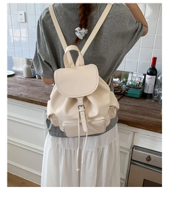 Detailed back view of a minimalist cream white soft leather backpack with drawstring closure