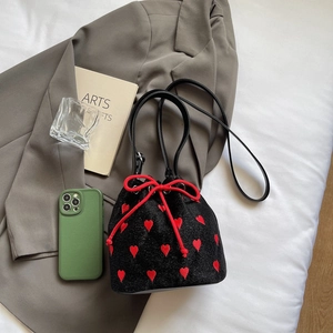 Fashionable black drawstring bucket bag with red heart embroidery and sleek leather strap