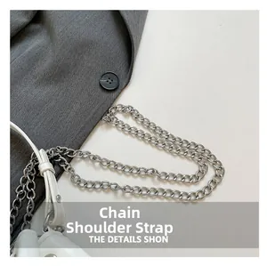 Detailed close-up of the double silver metal chain strap on a white leather bucket bag