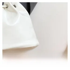 Detailed macro view of white faux leather texture with silver metal eyelets on a bucket bag