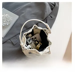 Internal view of white drawstring bucket bag showing storage capacity for daily items