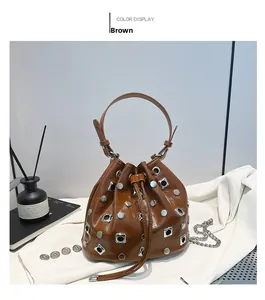 Detail of a brown drawstring bucket bag featuring silver rivets and a chain strap