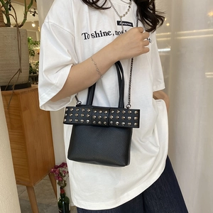 Punk style black pebbled leather mini crossbody bag with studded bow and chain strap
