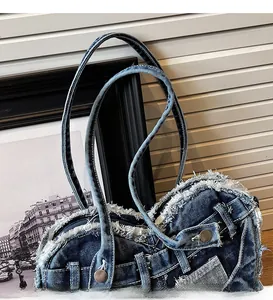 Detail of vintage washed blue denim shoulder bag with frayed edges and metal buttons