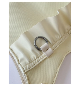Detailed macro view of beige pleated nylon fabric with a silver D-ring metal attachment