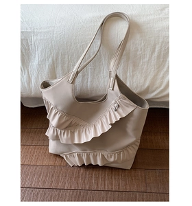 Detailed close-up of cream shoulder tote bag with elegant ruffled lace layer design