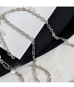 Detailed macro shot of a sleek silver metal chain strap for a luxury evening clutch bag