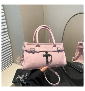 Detail of pink crossbody bag with vintage silver cross charm and detachable strap