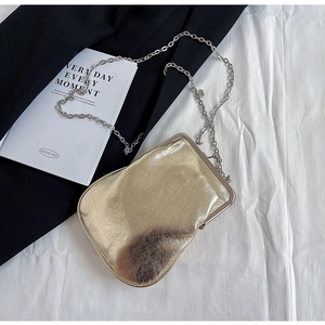 Detailed view of the gold metallic textured surface and silver chain strap on the bag