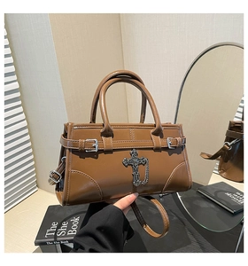 Detailed view of brown retro small square bag with metallic gothic cross and chain