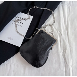 Detail of black glossy mini square bag featuring silver vintage metal clasp and fine chain