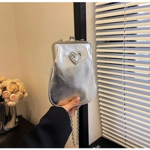 Detail of silver metallic evening bag with pearl heart and vintage metal clasp