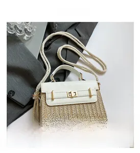 Détail du sac boîte en paille avec rabat en cuir blanc et bandoulière en corde rustique
