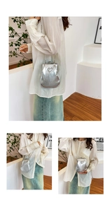 Detail of silver metallic PU crossbody bag with heart pattern and chain strap