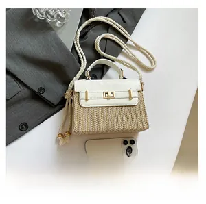 Détail du petit sac boîte en paille avec rabat en cuir blanc et fermoir doré rotatif