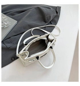 Top view of white Boston bag interior with multiple compartments and a black suit jacket