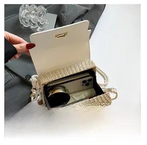 Vue intérieure du sac bandoulière en paille montrant l'espace pour téléphone et maquillage