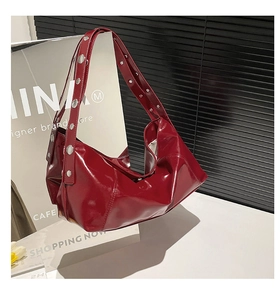 Detailed close-up of wine red patent leather shoulder bag with silver metallic rivets