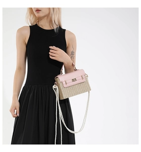 Détail du sac en paille tissée avec rabat en cuir rose et fermoir doré rotatif