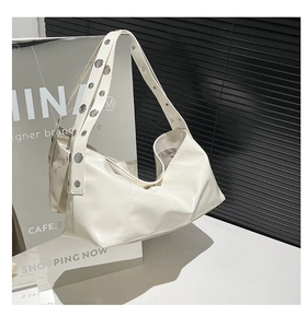Close-up of cream hobo bag with large silver buckle and pleated synthetic leather detail